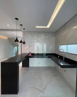 a large kitchen with a black counter and a sink at Dar rahma in Khenifra