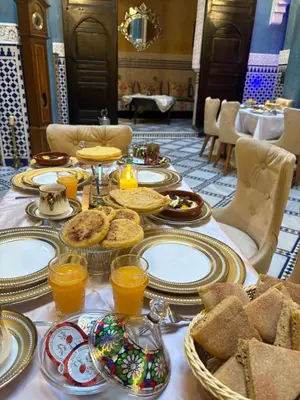 a table with plates of food and bread on it at Dar Laabi - Riad Aya in Fès