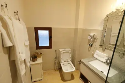 a bathroom with a toilet and a sink and a window at Dar Laabi - Riad Aya in Fès