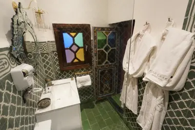 a bathroom with a sink and a stained glass window at Dar Laabi - Riad Aya in Fès