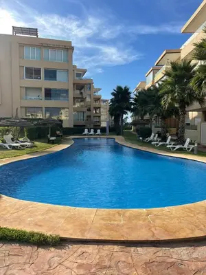 a large swimming pool in front of a building at Appartement à louer à BOUZNIKA OUED CHERRAT in Oulad Akkou