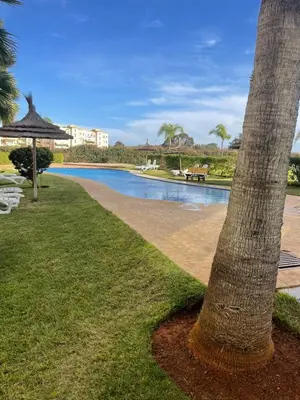 a palm tree sitting next to a body of water at Appartement à louer à BOUZNIKA OUED CHERRAT in Oulad Akkou