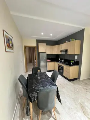 a kitchen with a table and chairs in a room at Appartement à louer à BOUZNIKA OUED CHERRAT in Oulad Akkou