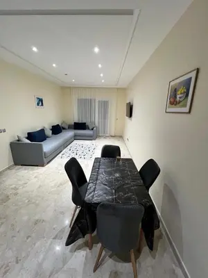 a living room with a table and chairs and a couch at Appartement à louer à BOUZNIKA OUED CHERRAT in Oulad Akkou