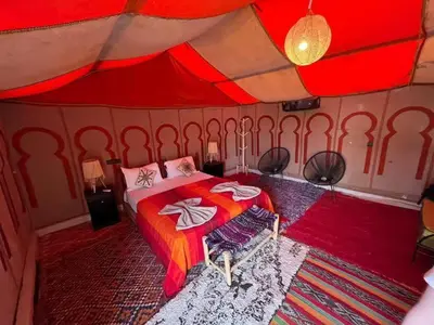 a bedroom with a bed in a tent at Golden Silence Camp in Merzouga