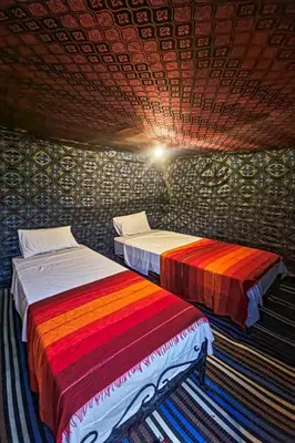 two beds sitting next to each other in a room at Golden Silence Camp in Merzouga