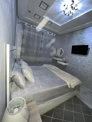 a bedroom with a bed in a room with a tv at Shahd in Meknès