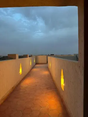 a hallway with lights on the side of a building at Maison El Alia in Merzouga