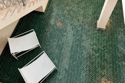 an overhead view of two white chairs on a green floor at Maison El Alia in Merzouga