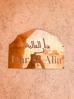 a sign on a wall with the words dar ahhtar at Maison El Alia in Merzouga