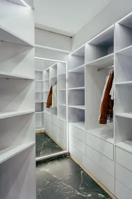 a walk in closet with white walls and shelves at Romilli atlas in Sbiti