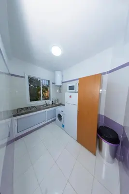 a white kitchen with a sink and a dishwasher at Royal Deluxe Fez in Fès