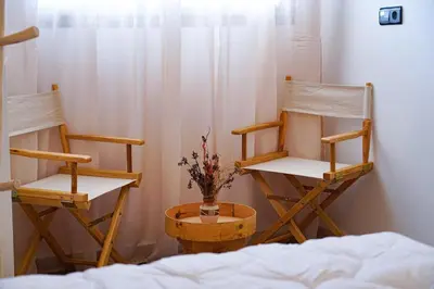 two rocking chairs and a vase of flowers in a room at Happiness Apartment in Ouarzazate