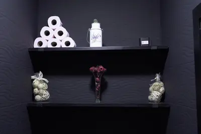 a black shelf with a vase and other items on it at Happiness Apartment in Ouarzazate