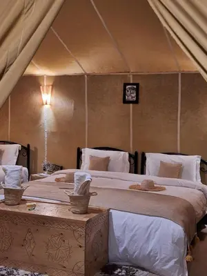 a bedroom with two beds in a tent at Merzouga Desert Night Luxury Camp Tours & Cozy Rooms in Rissani