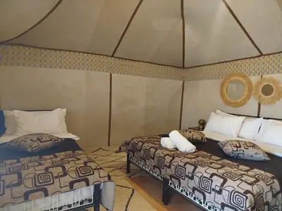 a room with two beds in a room at Merzouga Desert Night Luxury Camp Tours & Cozy Rooms in Rissani