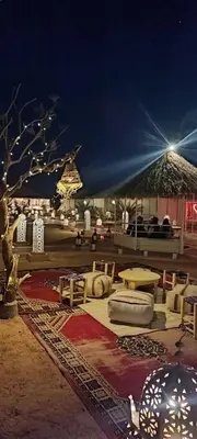 a pavilion with a table and chairs and a tent at Merzouga Desert Night Luxury Camp Tours & Cozy Rooms in Rissani