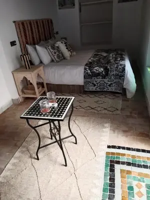a room with a bed and a table with a bed at Riad la Fíbula de Nora in Fès