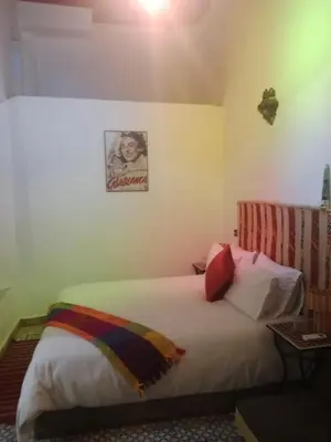 a bed in a room with a picture on the wall at Riad la Fíbula de Nora in Fès