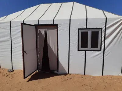 a white tent with a door in the sand at StarlitDesertCamp in El Gouera