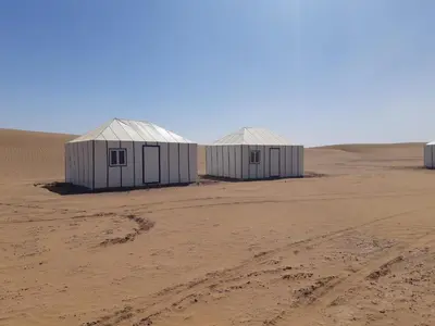 two buildings in the middle of a desert at StarlitDesertCamp in El Gouera