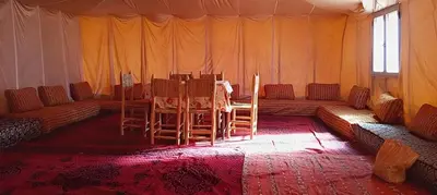 a room with a table and chairs in a tent at StarlitDesertCamp in El Gouera