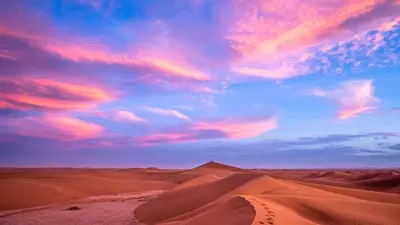 a desert with a cloudy sky and sand dunes at Bivouac Dune Iriki in Foum Zguid