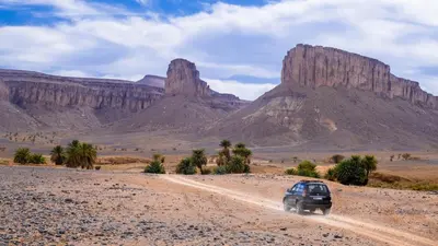 a car driving on a dirt road in the desert at Bivouac Dune Iriki in Foum Zguid