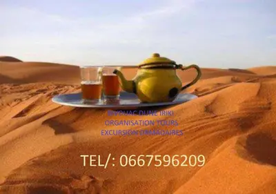 a plate with a tea pot and a glass in the desert at Bivouac Dune Iriki in Foum Zguid