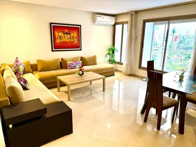 a living room with a couch and a table at Appartement avec vue sur parc et Wifi 100 Mo in Fès