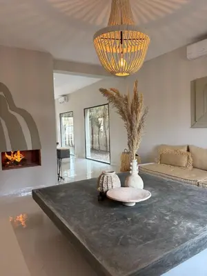 a large living room with a table and a chandelier at Villa Loaïa in Marrakech