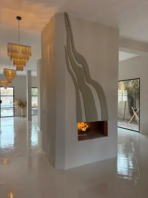 a living room with a fireplace on the wall at Villa Loaïa in Marrakech