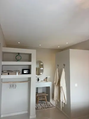 a bathroom with white walls and a sink and a mirror at Villa Loaïa in Marrakech