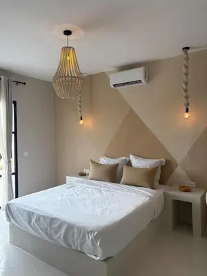a bedroom with a large white bed and a chandelier at Villa Loaïa in Marrakech