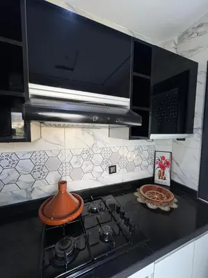 a kitchen with a stove and a microwave at Home sweet home in Fès