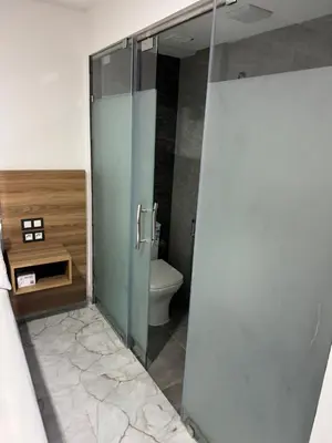 a bathroom with a glass shower with a toilet at Hôtel kairouan in Fès