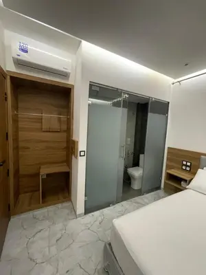 a bedroom with a bed and a bathroom with a shower at Hôtel kairouan in Fès