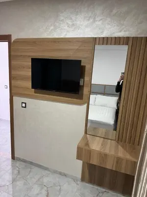 a room with a mirror and a tv on a wall at Hôtel kairouan in Fès