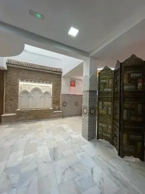 a large room with a tile floor and a room with cabinets at Hôtel kairouan in Fès