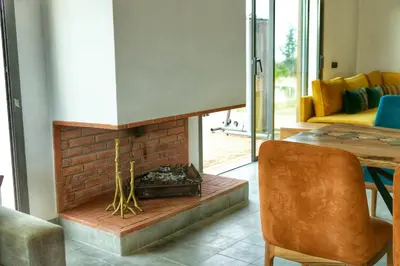 a living room with a brick fireplace and a chair at Le Clos des Oliviers Marrakech Villa & Piscine in Marrakech