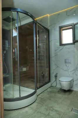 a bathroom with a glass shower and a toilet at Le Clos des Oliviers Marrakech Villa & Piscine in Marrakech