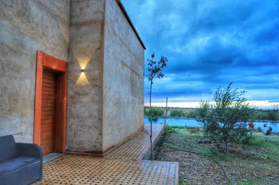 a stone building with a couch on a patio at Le Clos des Oliviers Marrakech Villa & Piscine in Marrakech