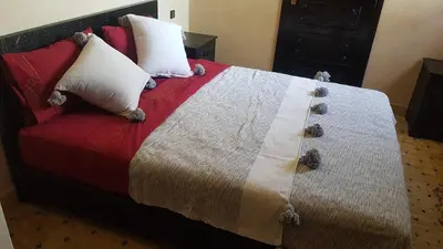a bedroom with a bed with a blanket and pillows at Authentic Riad with swimming pool and private garden