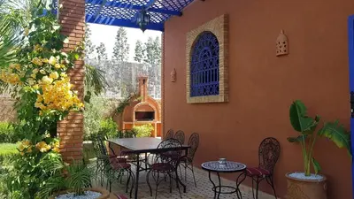 a patio with a table and chairs and a building at Authentic Riad with swimming pool and private garden