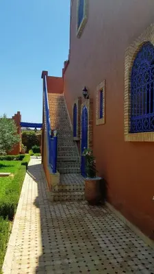 a building with blue doors and stairs in front of it at Authentic Riad with swimming pool and private garden
