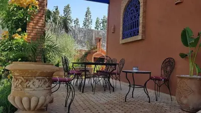 a patio with tables and chairs in a courtyard at Authentic Riad with swimming pool and private garden