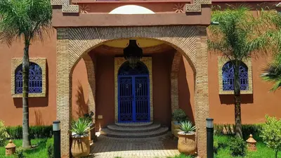 an entrance to a house with a blue door at Authentic Riad with swimming pool and private garden