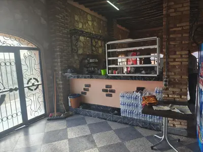 a room with a door and a shelf with bottles of water at Hotel El Golla in Er Rachidia