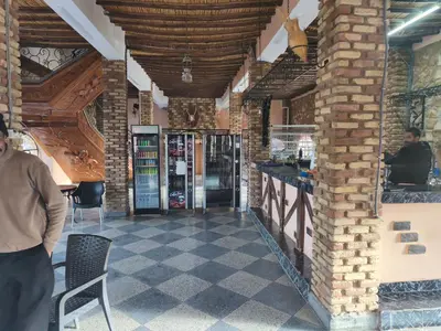 a man standing in front of a bar in a building at Hotel El Golla in Er Rachidia