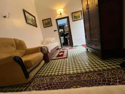 a living room with a couch and a mirror at Riad Dar Oum Albanin in Fès